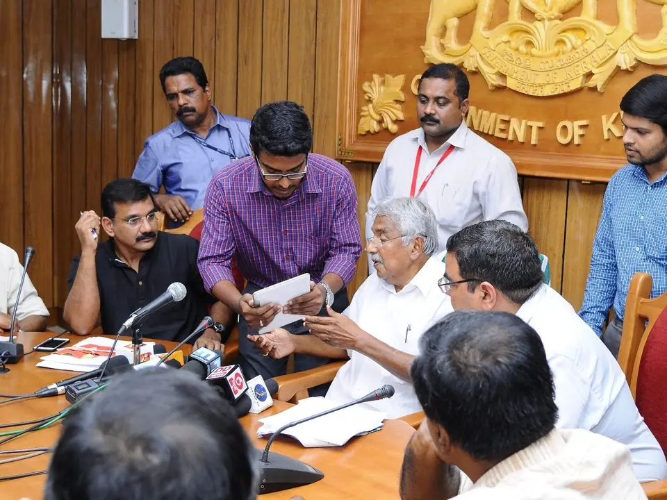 Blessan Kurien Thomas demonstrating the Kerala State Lottery Results app to Chief Minister Oommen Chandy