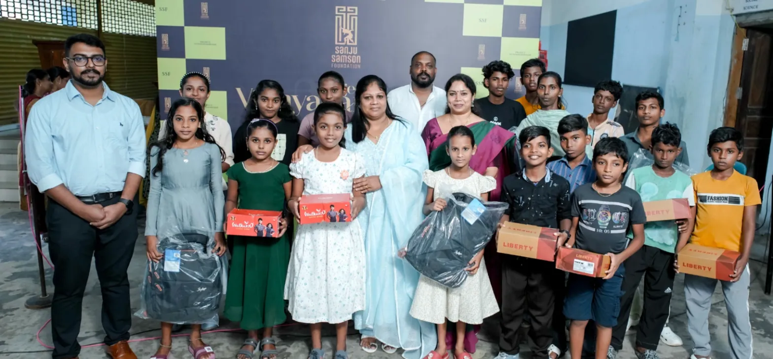 Blessan Kurien Thomas with Ligy Samson, Sanju Samson’s mother, and students receiving school bags and shoes under Project Vidyarambham, St. Mary’s HSS, Vizhinjam